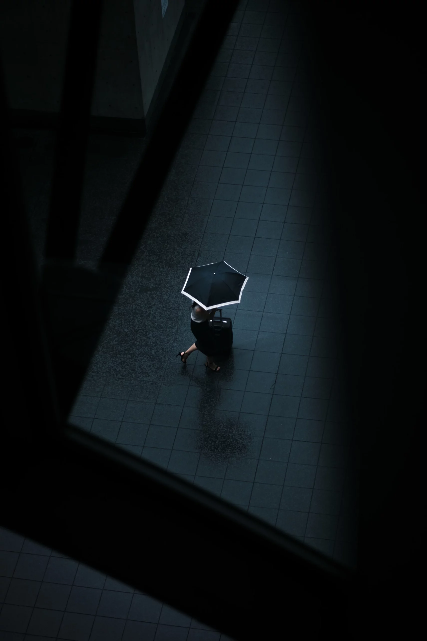 Eine Frau geht mit einem Regenschirm die Straße entlang.