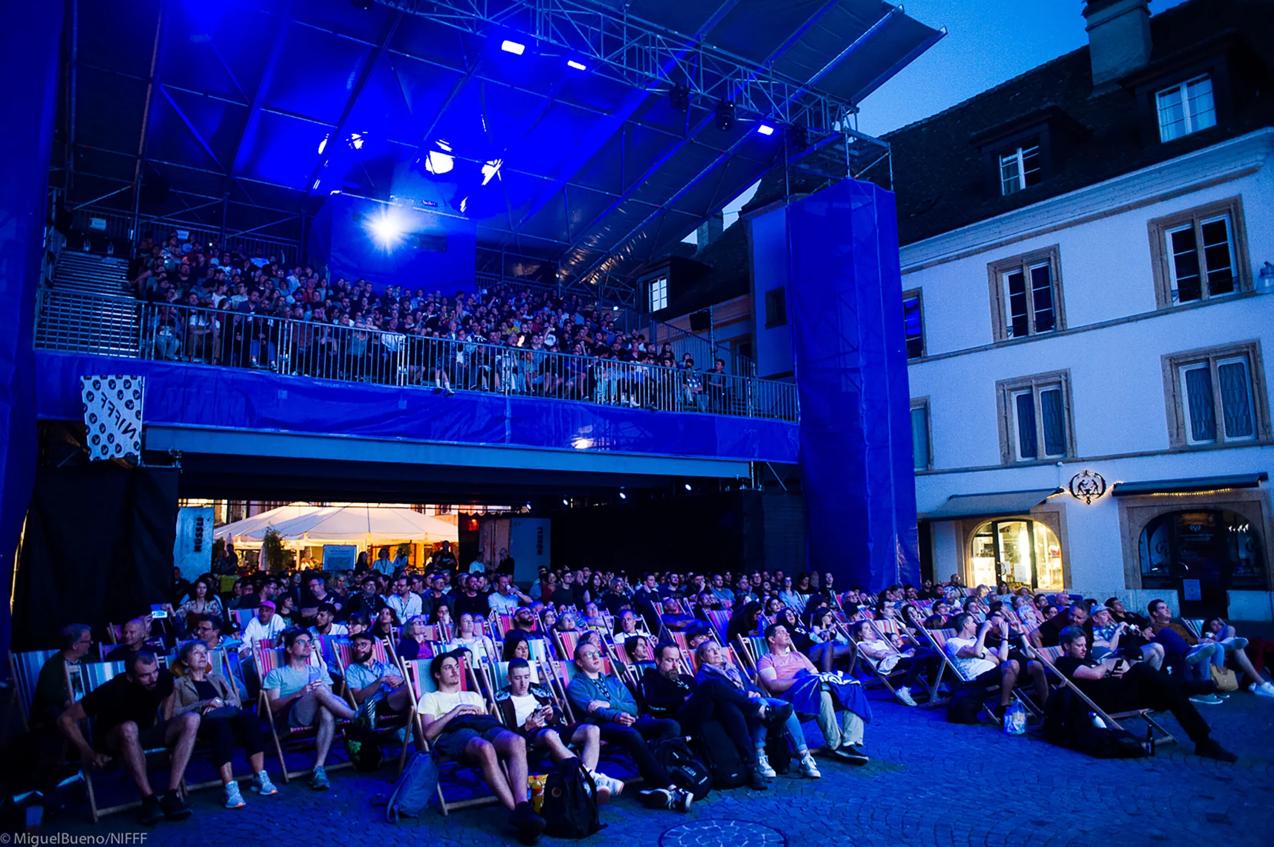 Une foule regarde un film durant un festival de cinéma.