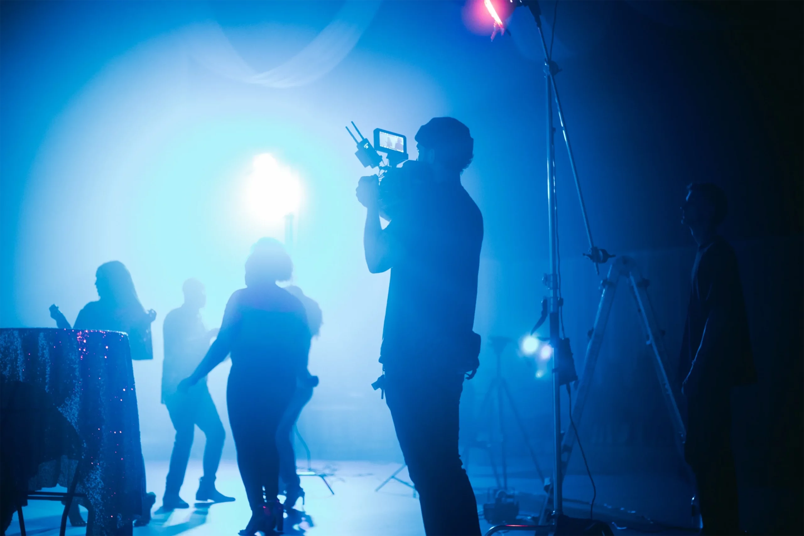 Ein Kameramann filmt eine Gruppenszene in einem Filmstudio.