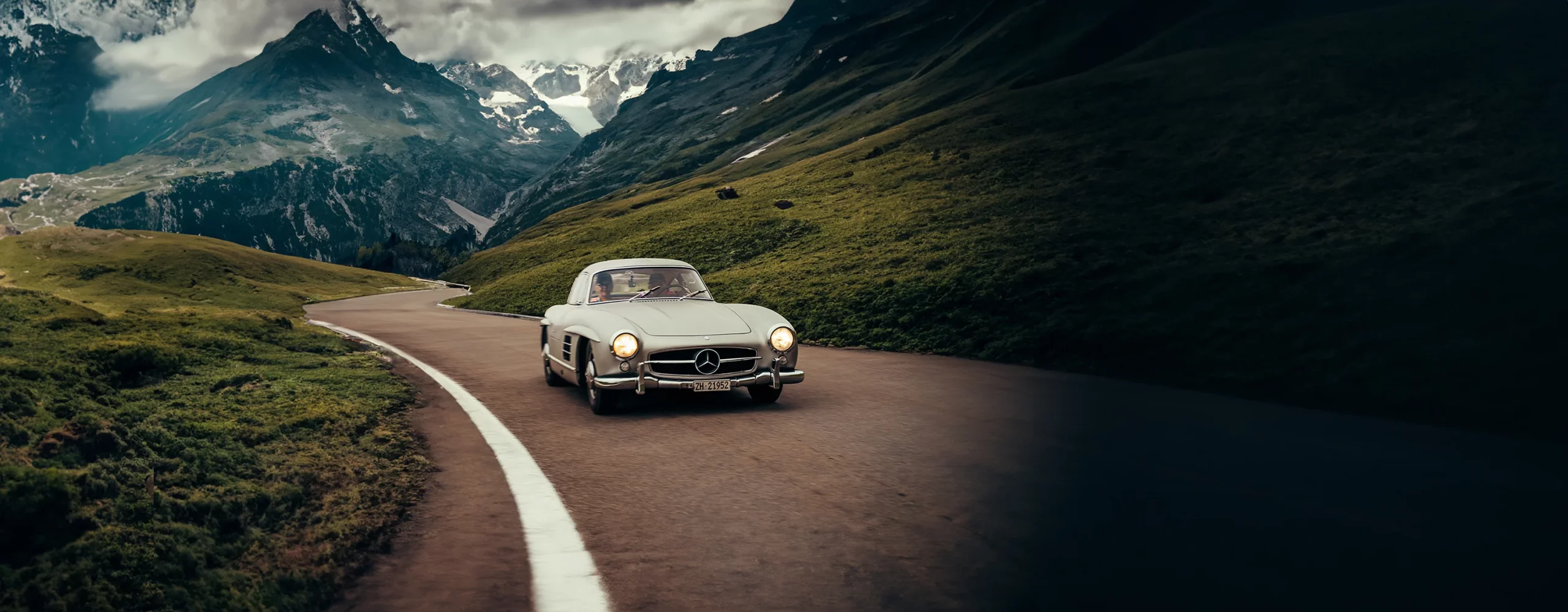 Une Mercedes 300 SL qui roule à travers un col en Suisse.