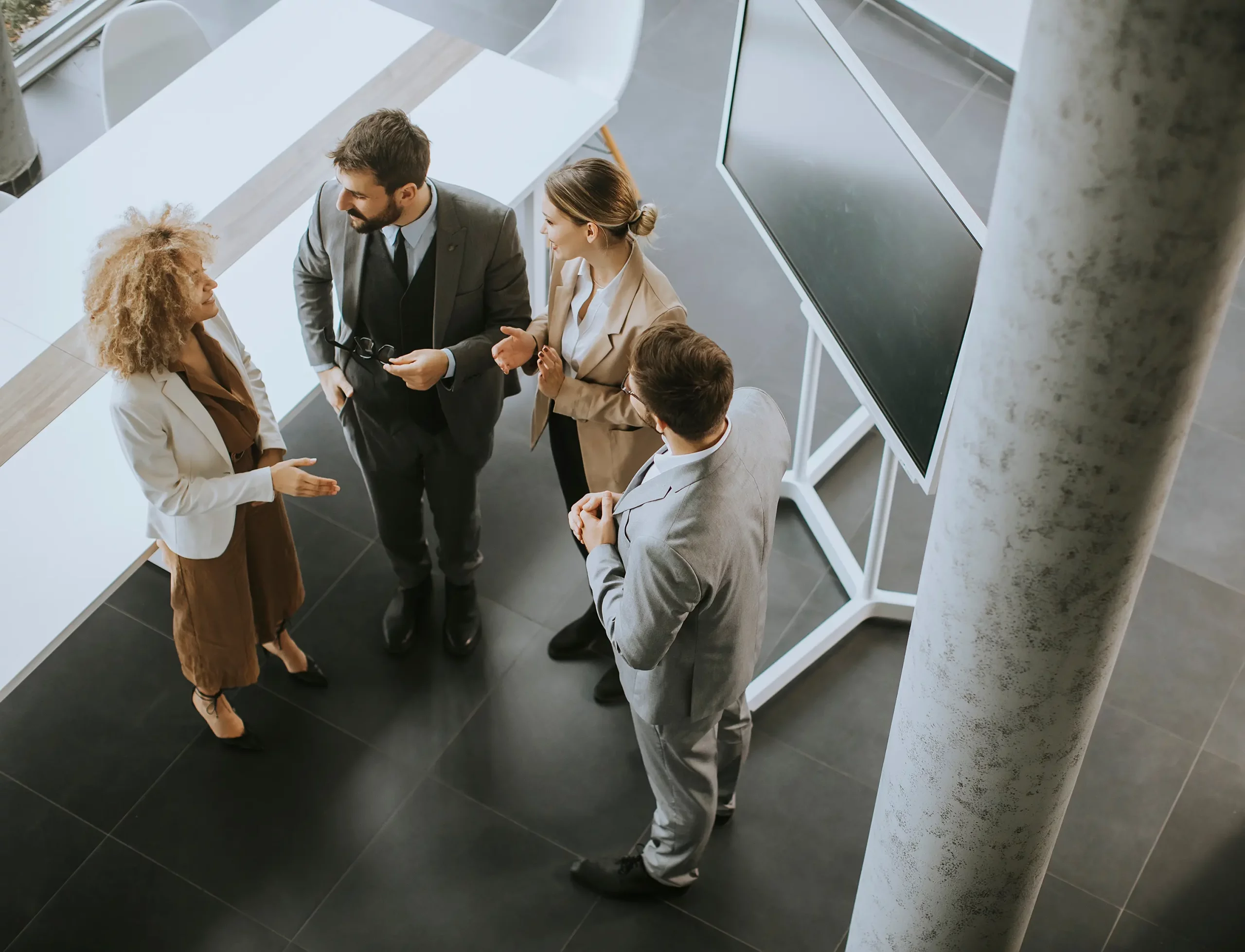 Zwei Frauen und zwei Männer diskutieren in einem Konferenzraum über ein Projekt.
