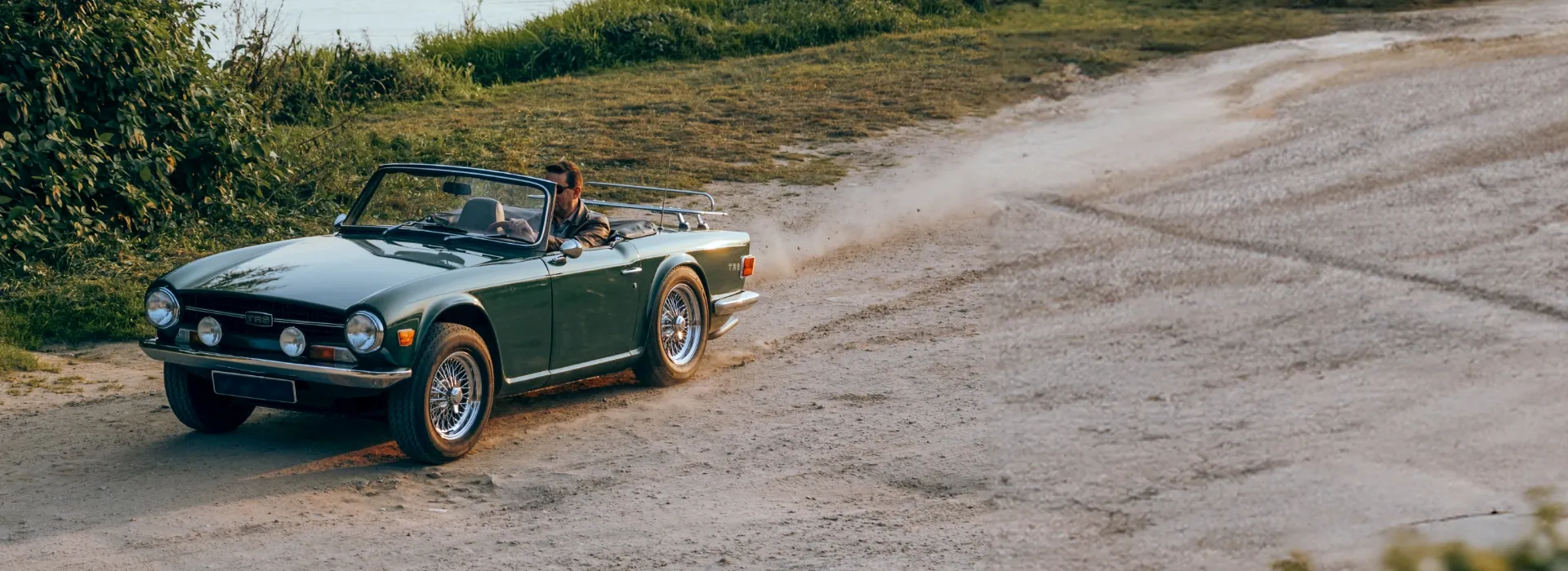 Ein Oldtimer, der auf einer Landstraße fährt.